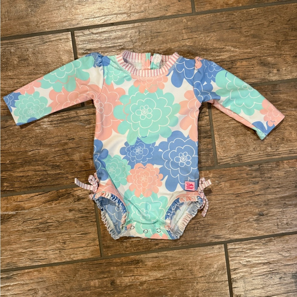 RuffleButts Long Sleeve One Piece Rash Guard in the Pastel Petals print